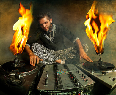 DJ adjusting turntables with flames on dark textured background, creating a dramatic scene.