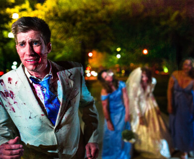 Man with bloodstains runs at night; three women in wedding attire blurred in background.
