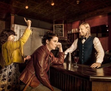 Person in yellow jacket interacts with another at a rustic bar with vintage ambiance.
